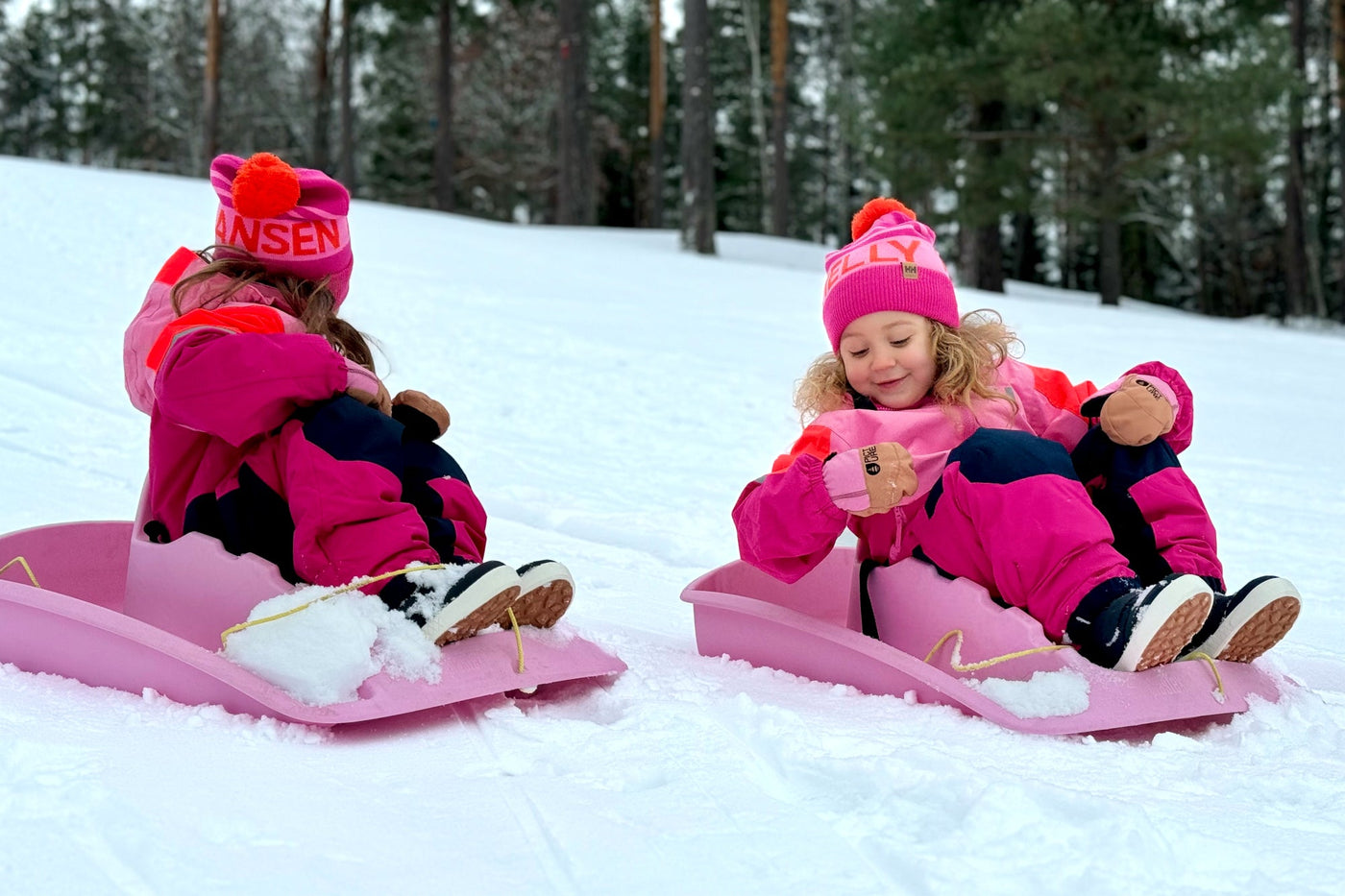 Lapset pulkkamäessä hyvin pukeutuneina