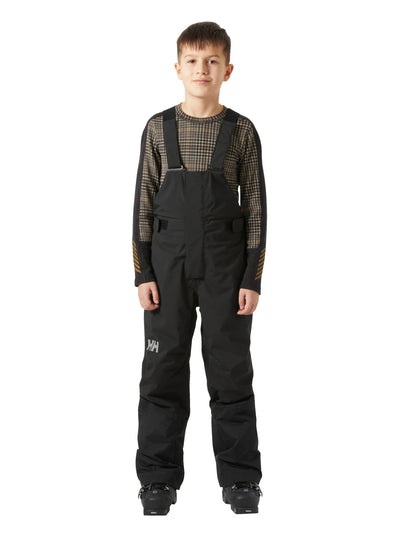 Helly Hansenin mustat lasten ja nuorten korkeavyötäröiset Bib pants -lasketteluhousut lapsen päällä edestä kuvattuna.