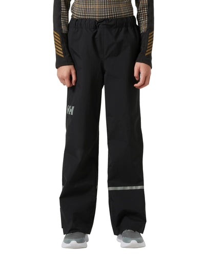 Helly Hansenin Jr Shelter HT Pants, lasten ja nuorten mustat kuorihousut edestä kuvattuna lapsen päällä