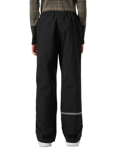 Helly Hansenin Jr Shelter HT Pants, lasten ja nuorten mustat kuorihousut edestä kuvattuna lapsen päällä