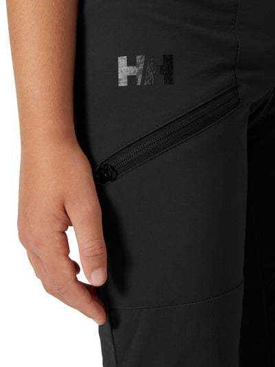 Helly Hansenin nuorten Loen softshell-housut värissä ebony lapsen päällä lähikuvassa HH-logo ja reisitasku