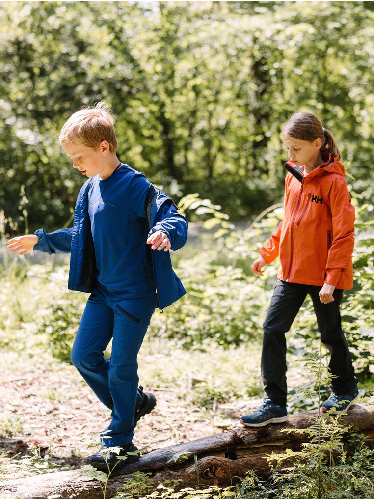 Helly Hansenin nuorten Loen softshell-housut kahdella lapsella päällä, jotka kävelevät