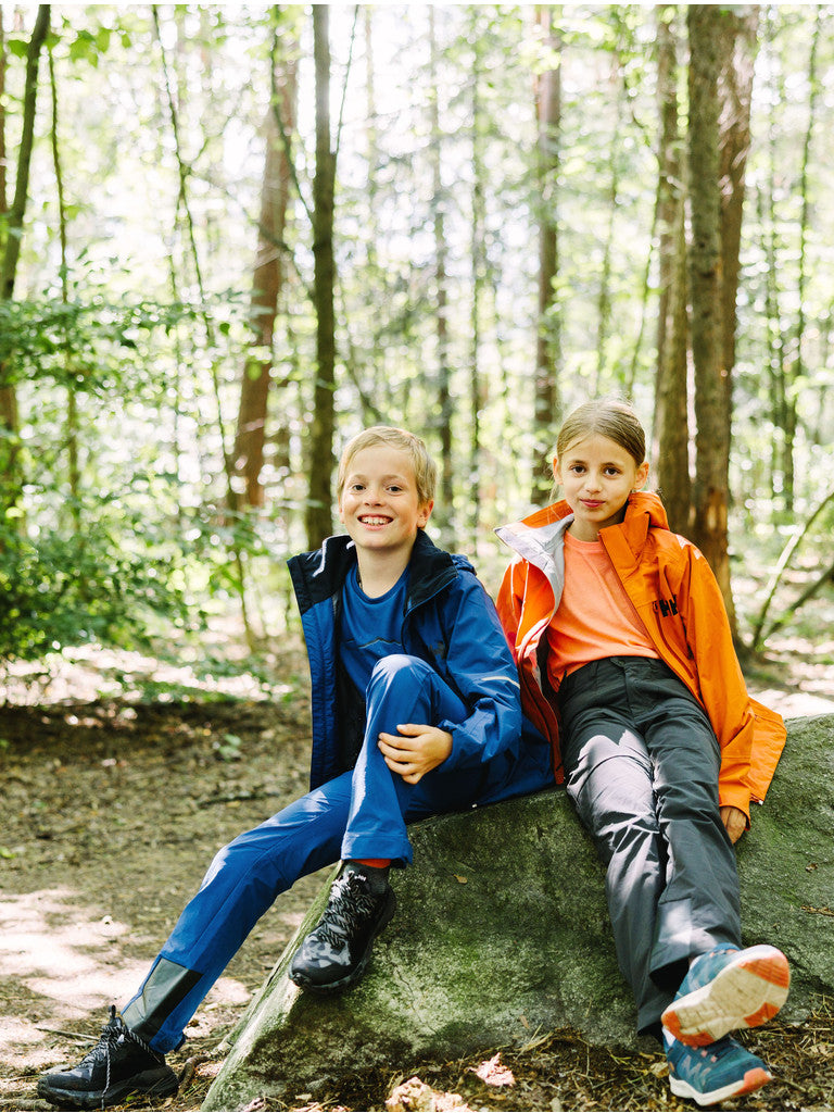Helly Hansenin nuorten Loen softshell-housut kahdella lapsella päällä, jotka istuvat