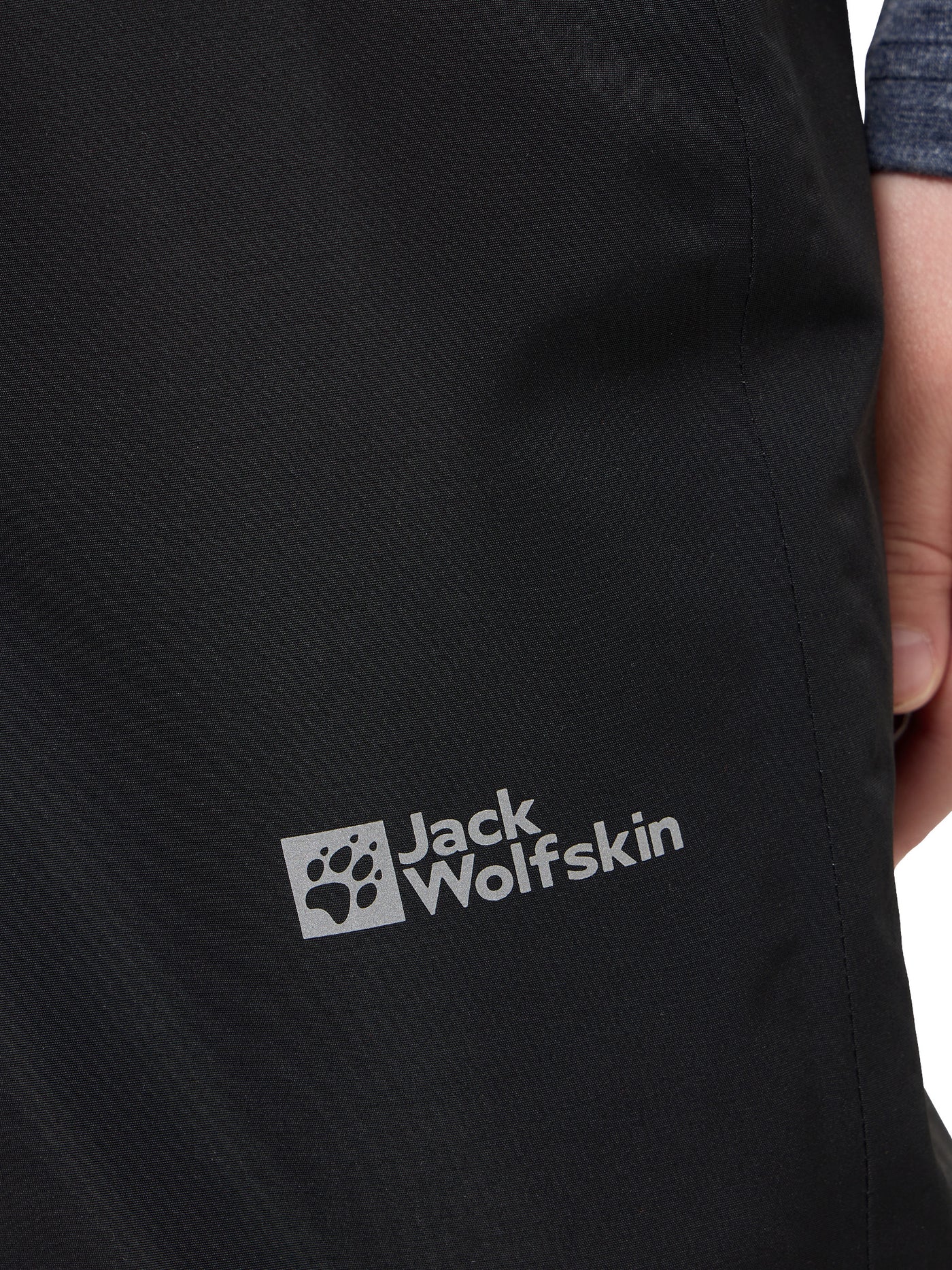 Jack Wolfskin lasten ja nuorten mustat Snowy Days talvihousut fleecevuorella lapsen päällä logo lähikuvassa