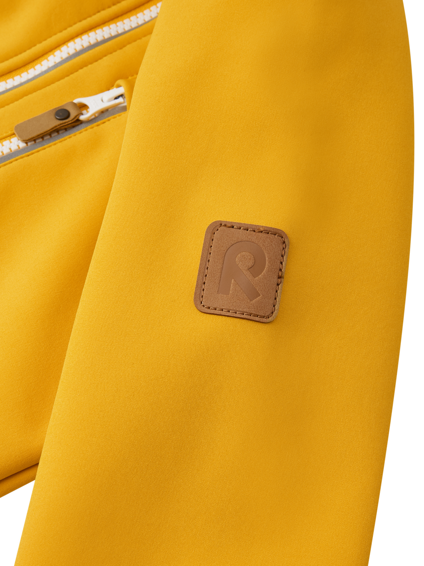 Reima Vantti lasten softshell takki värissä Chanterelle lähikuva hihan R-logosta