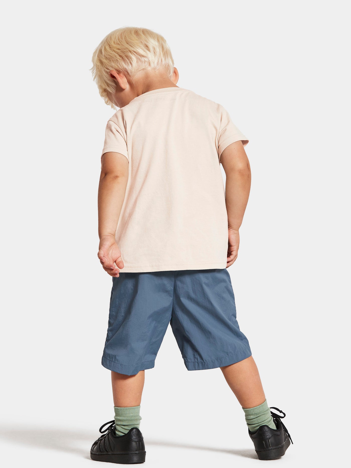 Pojan päällä Didriksonsin siniset Castor shortsit takaa kuvattuna