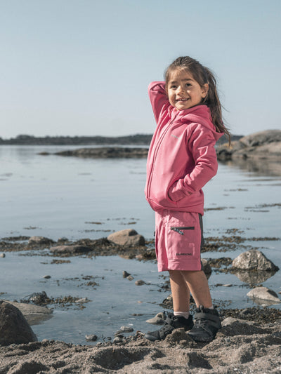 Tyttö seisoo rannalla ja hänellä on päällä Didriksonsin pinkit Ekoxen shortsit 