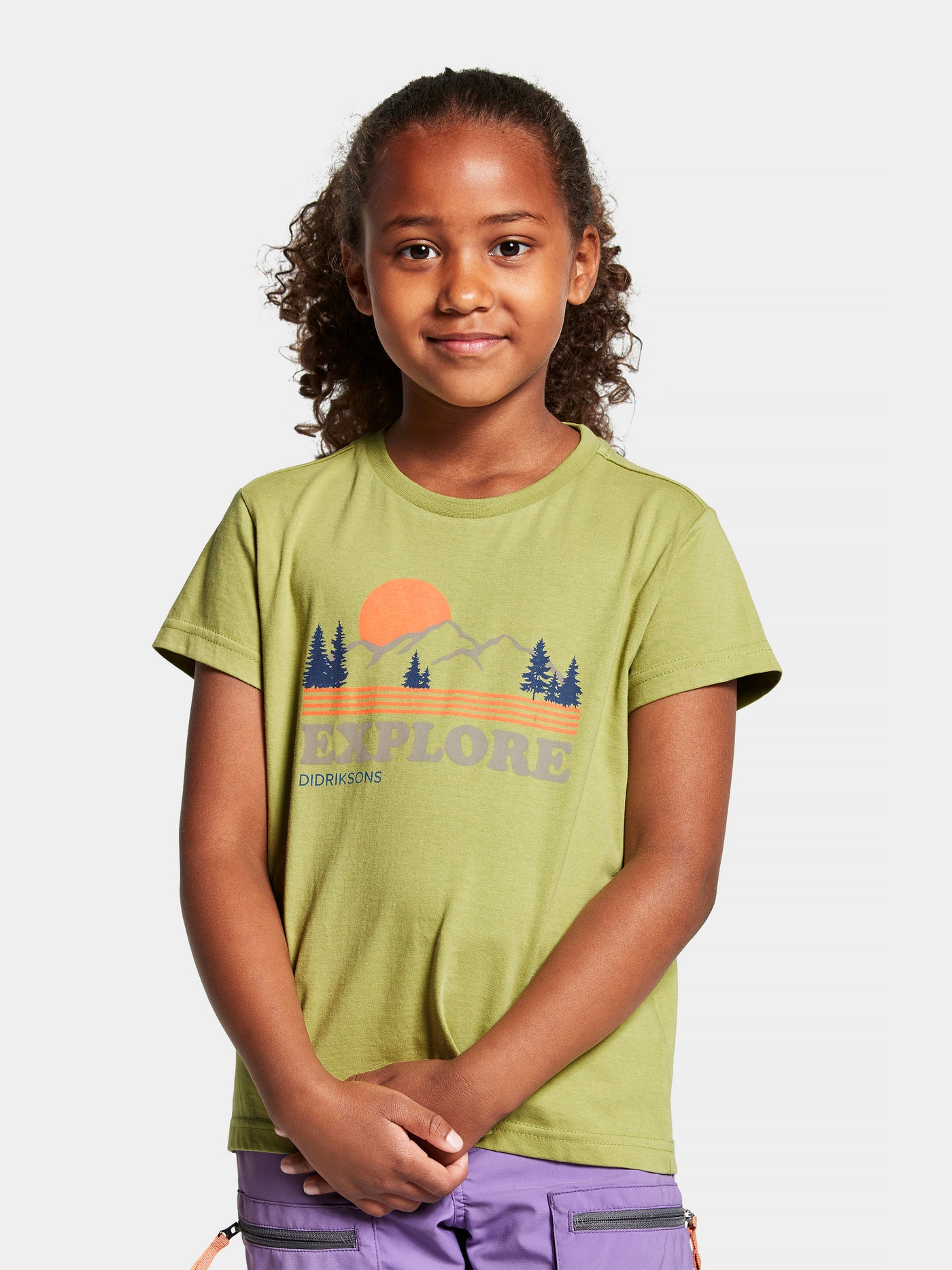 Didriksonsin lasten ja nuorten Mynta logo t-paita vaaleanvihreässä sävyssä tytön päällä edestä kuvattuna lähikuvassa