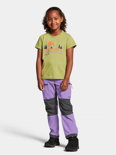 Didriksonsin lasten ja nuorten Mynta logo t-paita vaaleanvihreässä sävyssä tytön päällä edestä kuvattuna hieman kauempaa