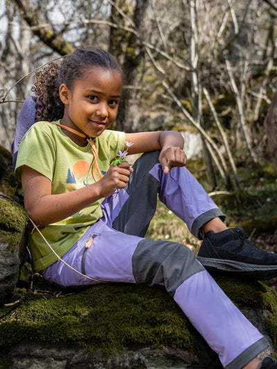 Didriksonsin lasten ja nuorten Mynta logo t-paita vaaleanvihreässä sävyssä tytön päällä ulkona maastossa