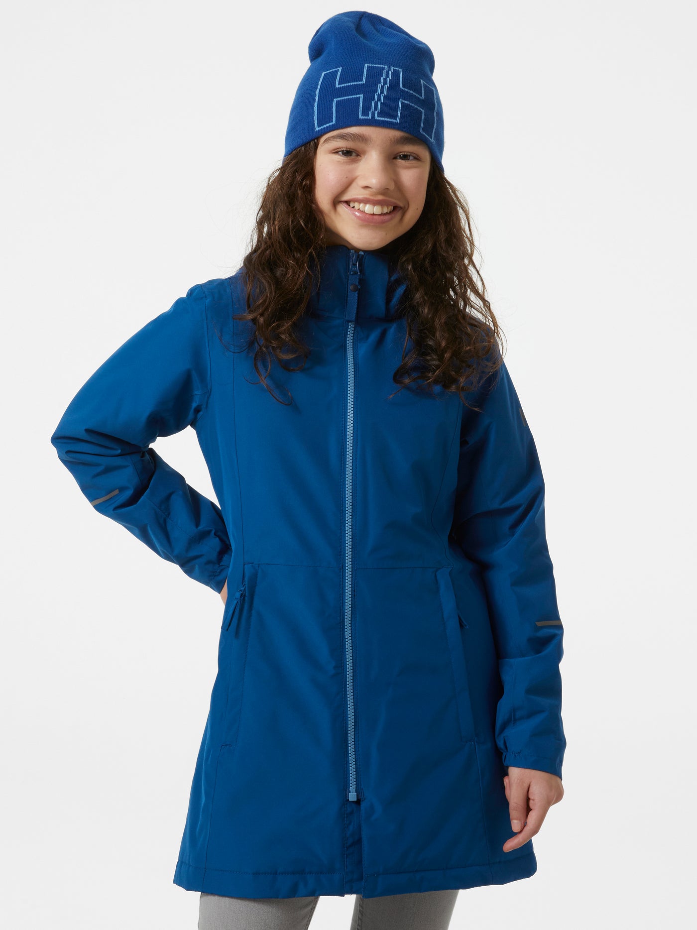 Helly Hansenin nuorten vuorellinen takki värissä Deep fjord tytön päällä