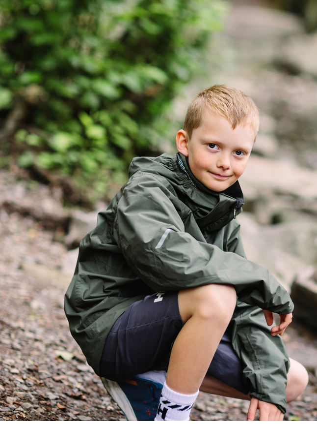 Helly Hansen Junior Loen takki värissä Forest Night pojan päällä luonnossa