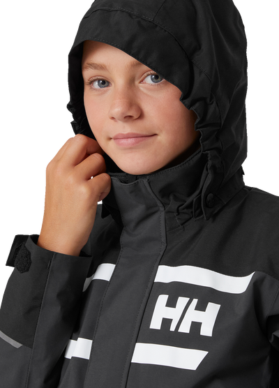 Helly Hansen Junior Salt Port 2.0 takki värissä Ebony tytöllä huppu päässä lähikuva