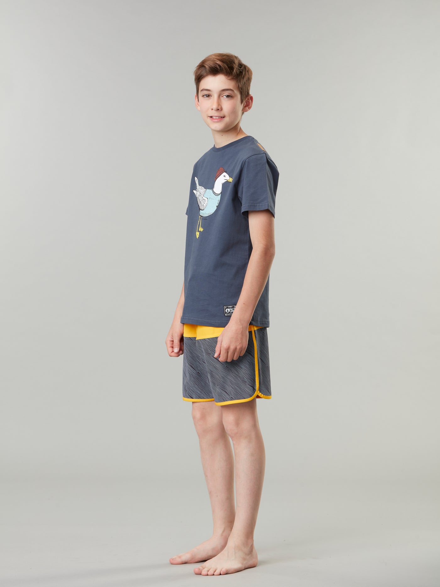 Pojan päällä Picture Organicin nuorten shortsit värissä Wood hieman sivuttain kuvattuna