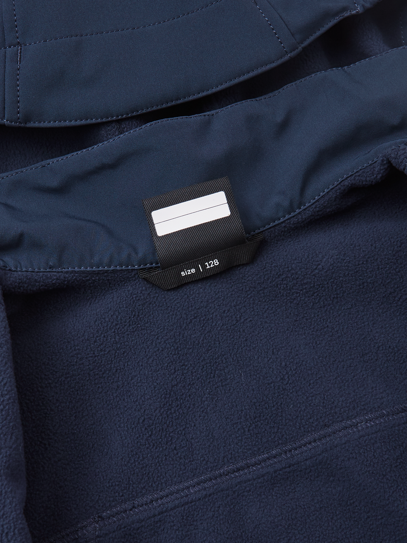Reima Espoo tummansininen softshell takki nimikointilappu kuvattuna