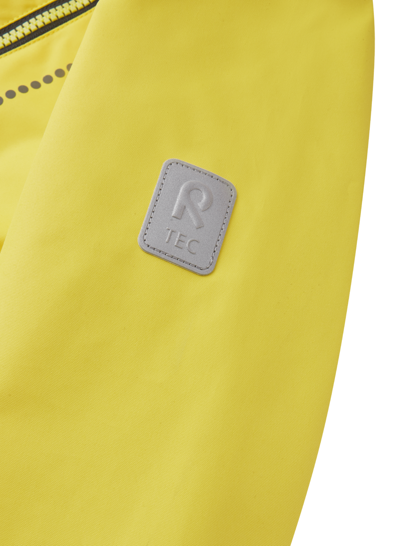 Reiman Kapelli Reimatec välikausihaalari keltaisessa värissä lähikuvassa Reimatec-merkki