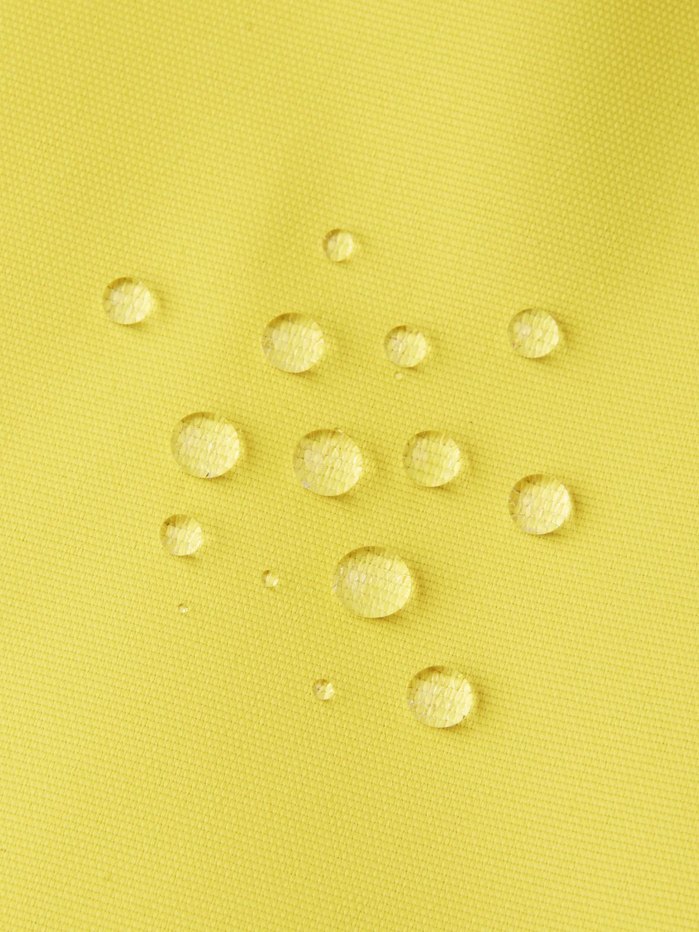 Reiman Kapelli Reimatec välikausihaalari keltaisessa värissä lähikuvassa kangas ja vesipisarat