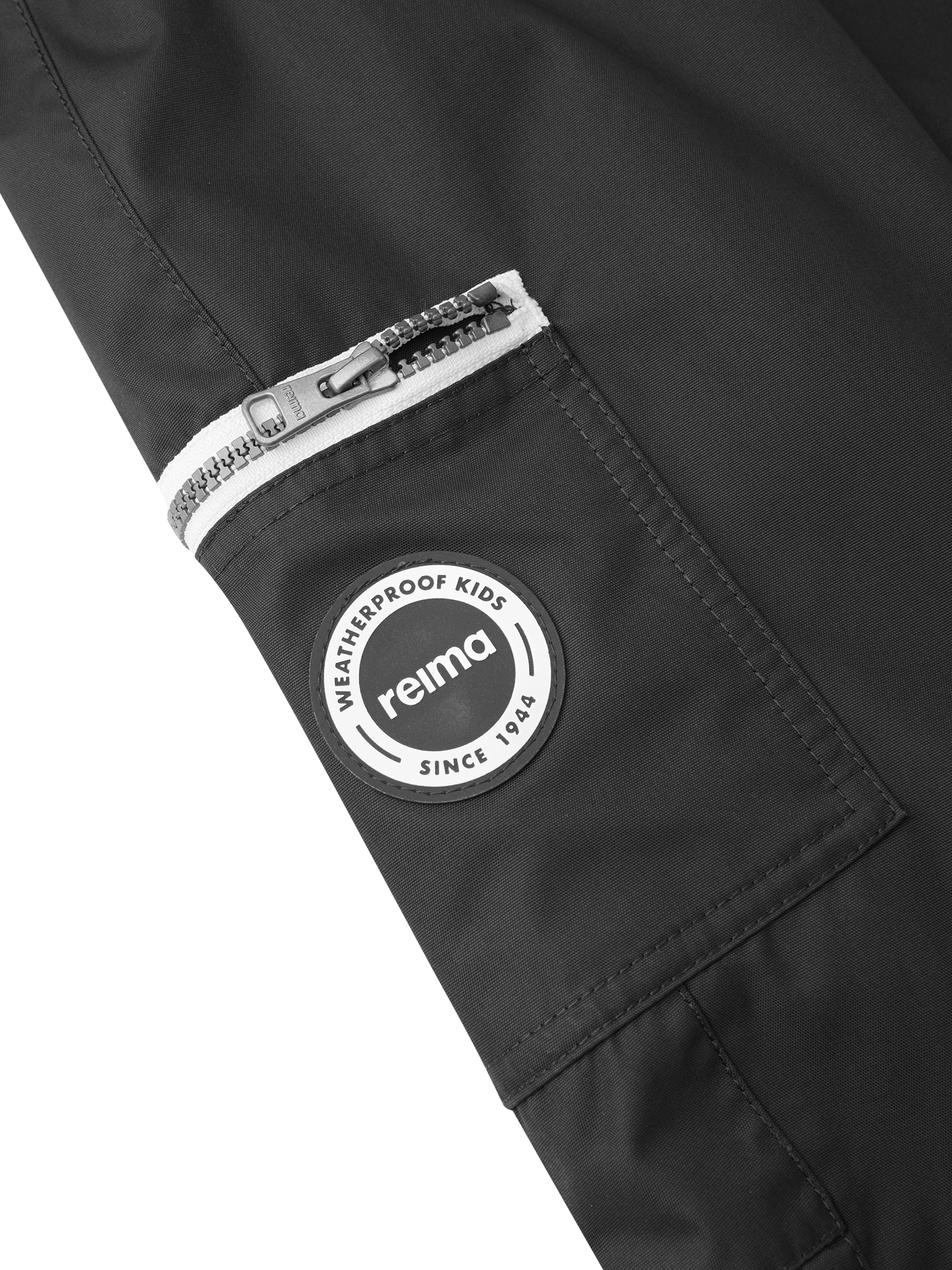 Reiman Reimatec Tiksi mustat kevyttoppahousut tasku ja Reima-merkki kuvattuna